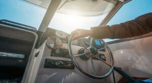 Boat-Or-Yacht-Captain-Hand-On-289543423-300x164 Boat Or Yacht Captain Hand On Boat Steering Wheel And Sea Naviga